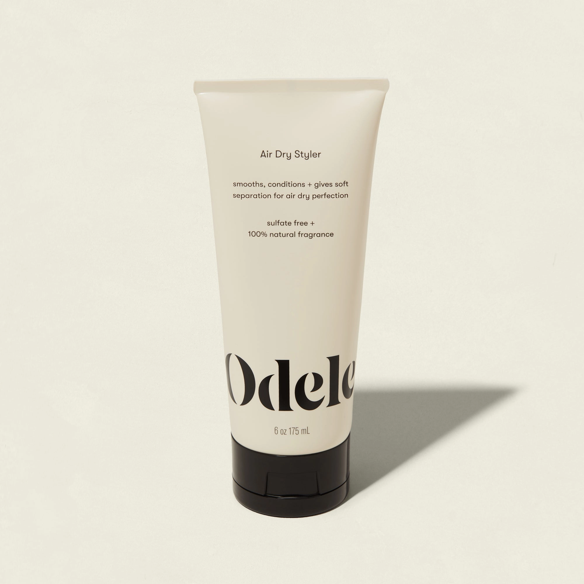 A tube of Odele Air Dry Styler with a black cap on a light background