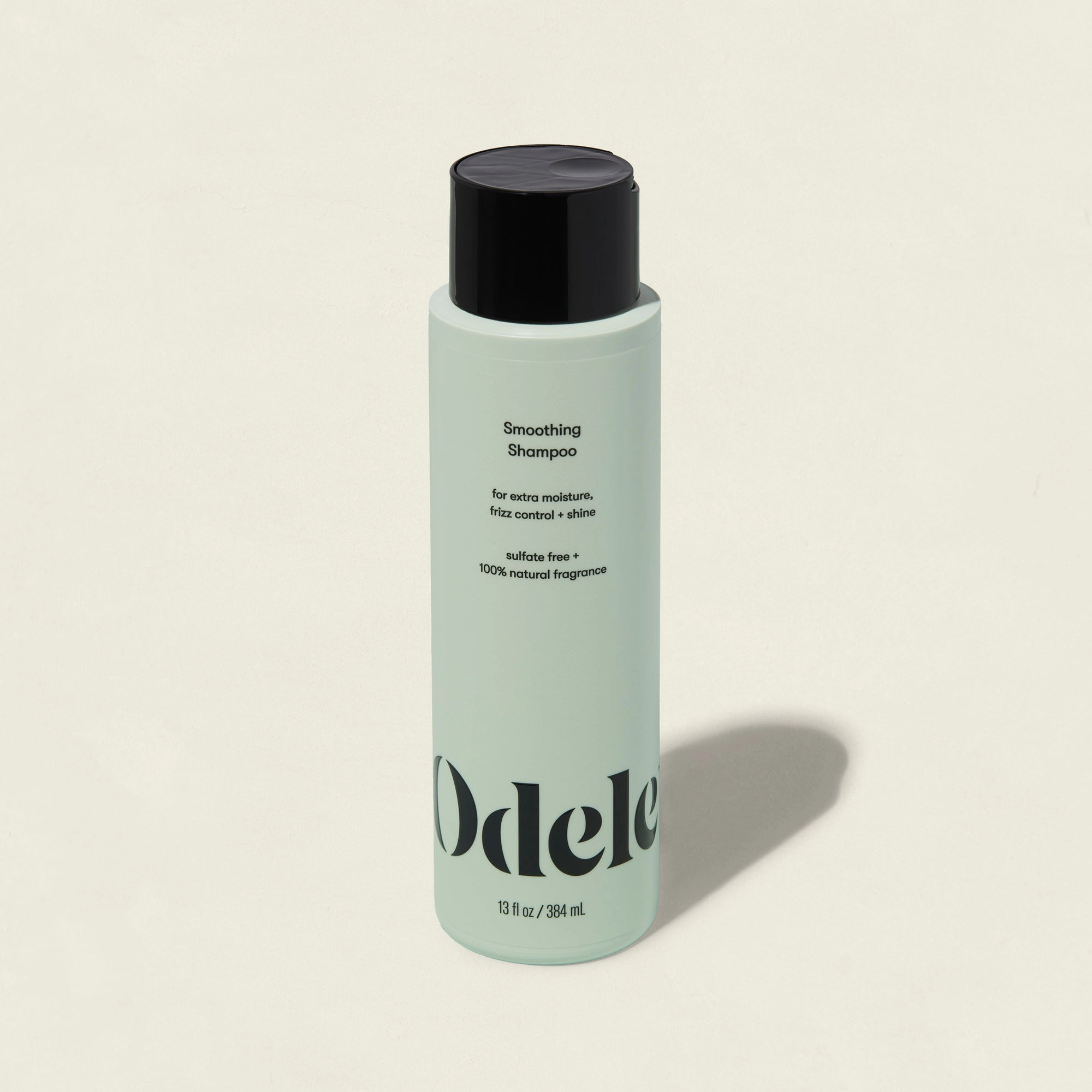 A light green bottle of Smoothing Shampoo with a black cap and minimalist branding on the front